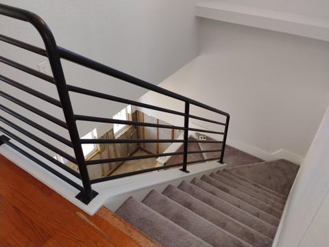 Modern staircase with gray steps and black metal railing
