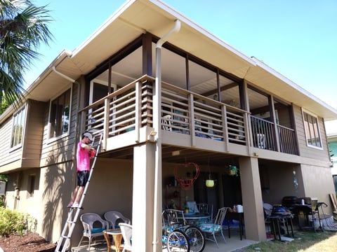 Elevated house with beige exterior and louver railings