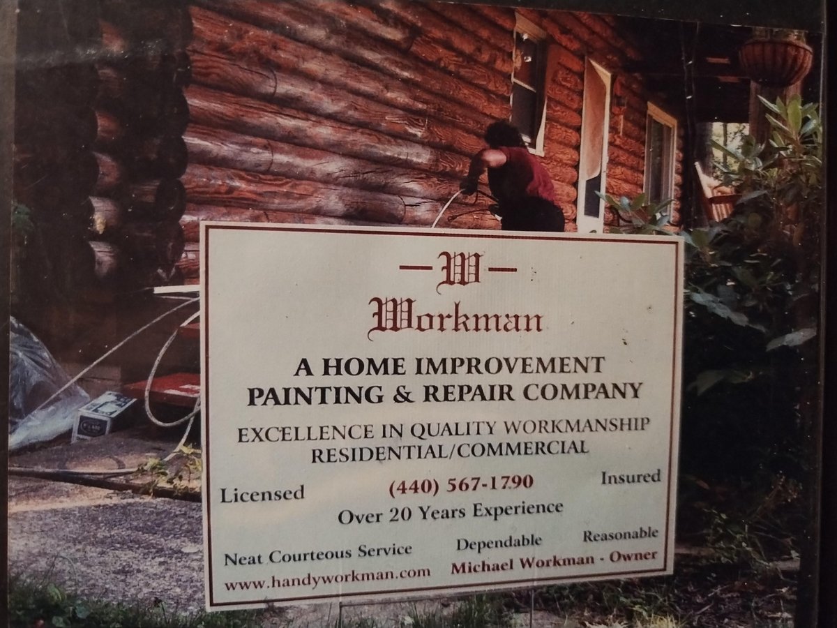 Workman home improvement painting and repair company sign displayed in front of a red wooden house