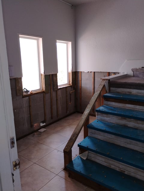 Stairwell with blue painted wooden steps during renovation