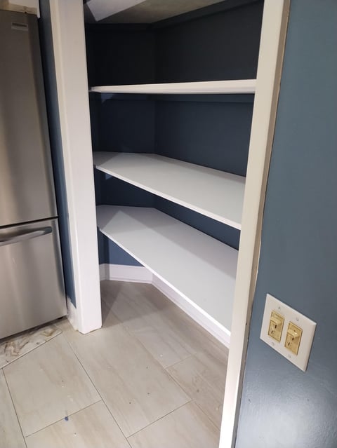 Empty white shelving unit in kitchen pantry