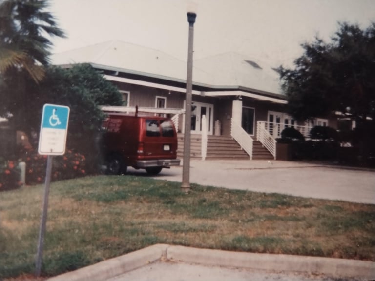 Single-story fire station with red fire truck parked outside, accessible entrance with wheelchair ramp and accessible parking sign