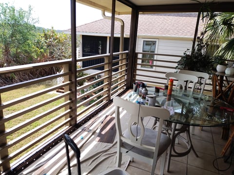 Covered outdoor patio with metal railing and furniture
